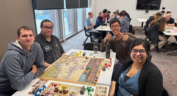 Groep mensen die samen een strategisch bordspel spelen tijdens een evenement van een buurtvereniging